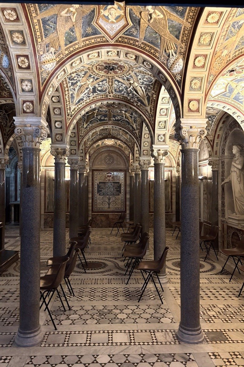 Crypte ornée de mosaïques avec colonnes de marbre et chaises pliantes
