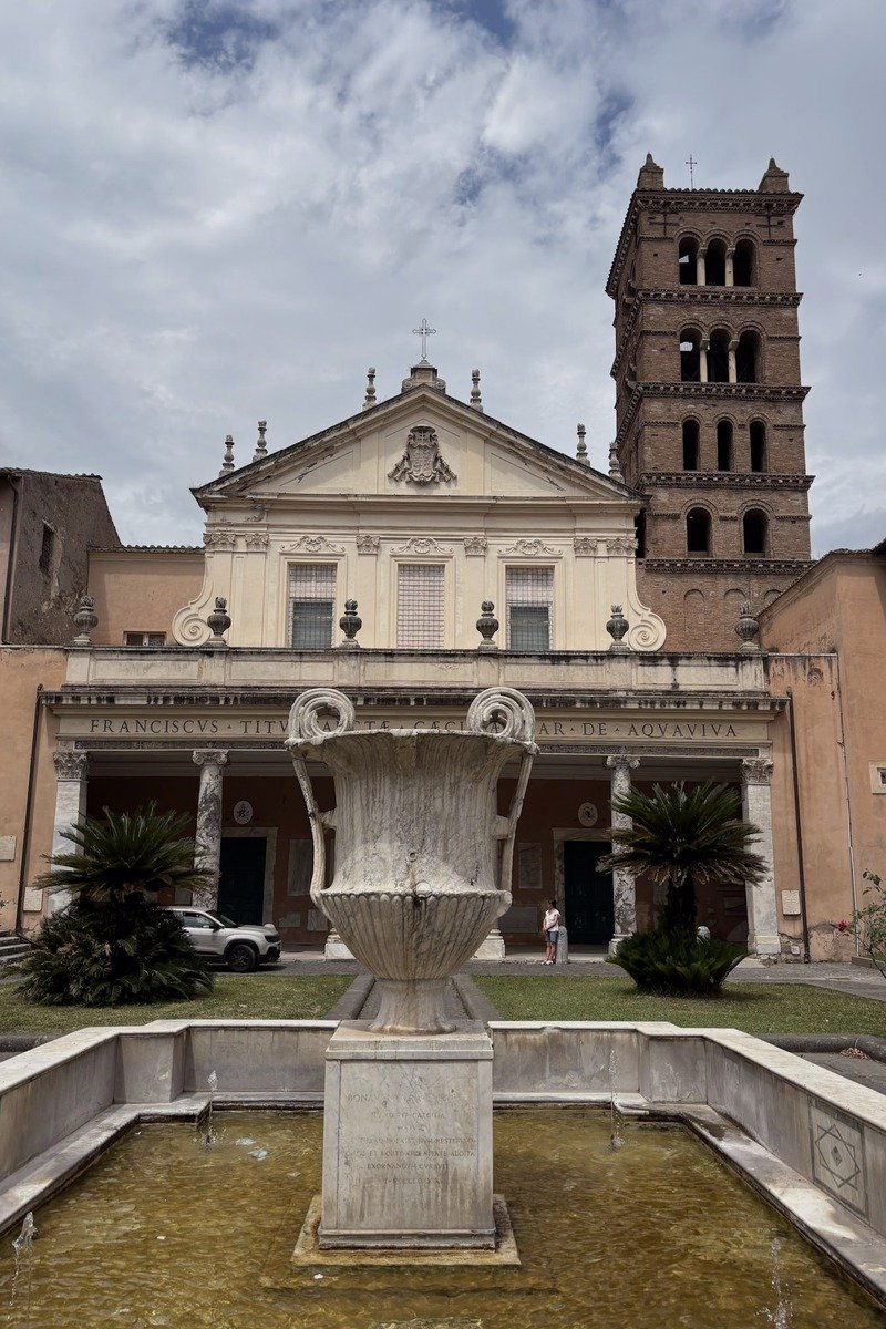 Façade baroque d'une église avec fontaine en marbre au premier plan