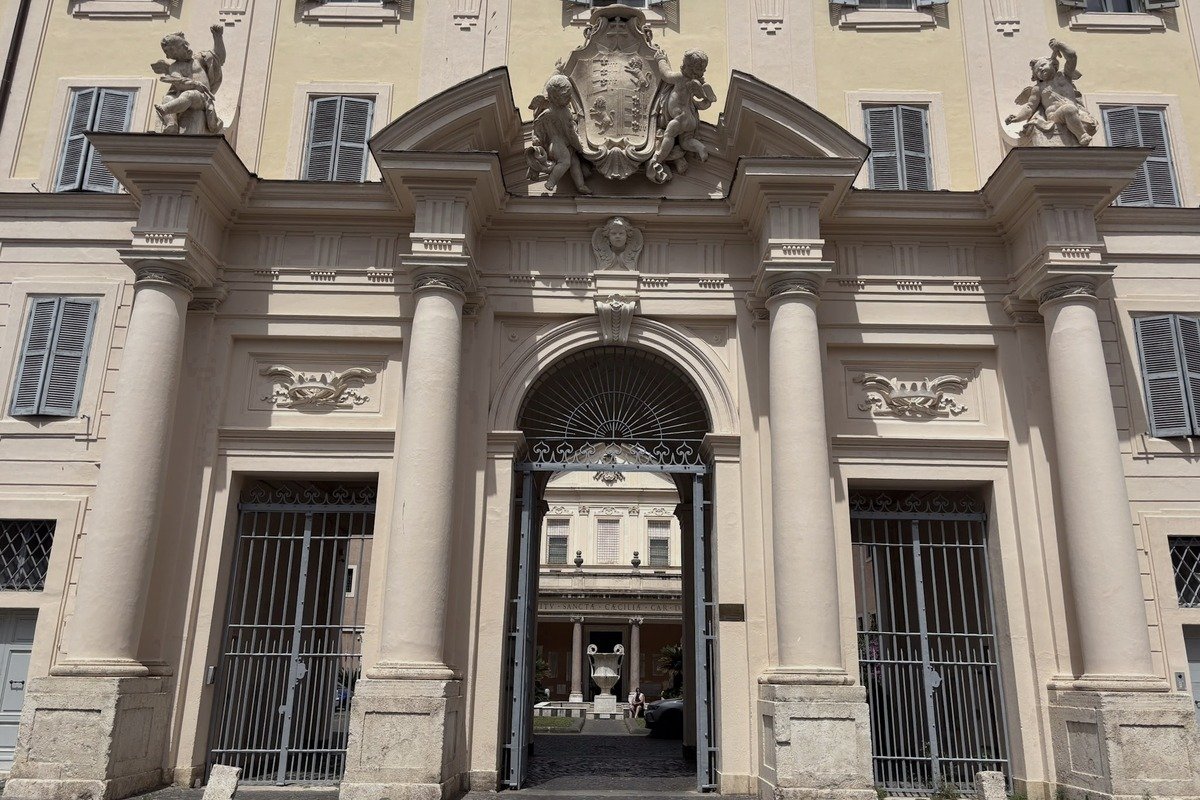 Portail baroque orné de colonnes et statues sur façade jaune pâle
