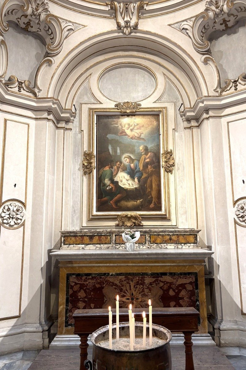 Chapelle baroque avec tableau de la Nativité, autel doré et bougies allumées