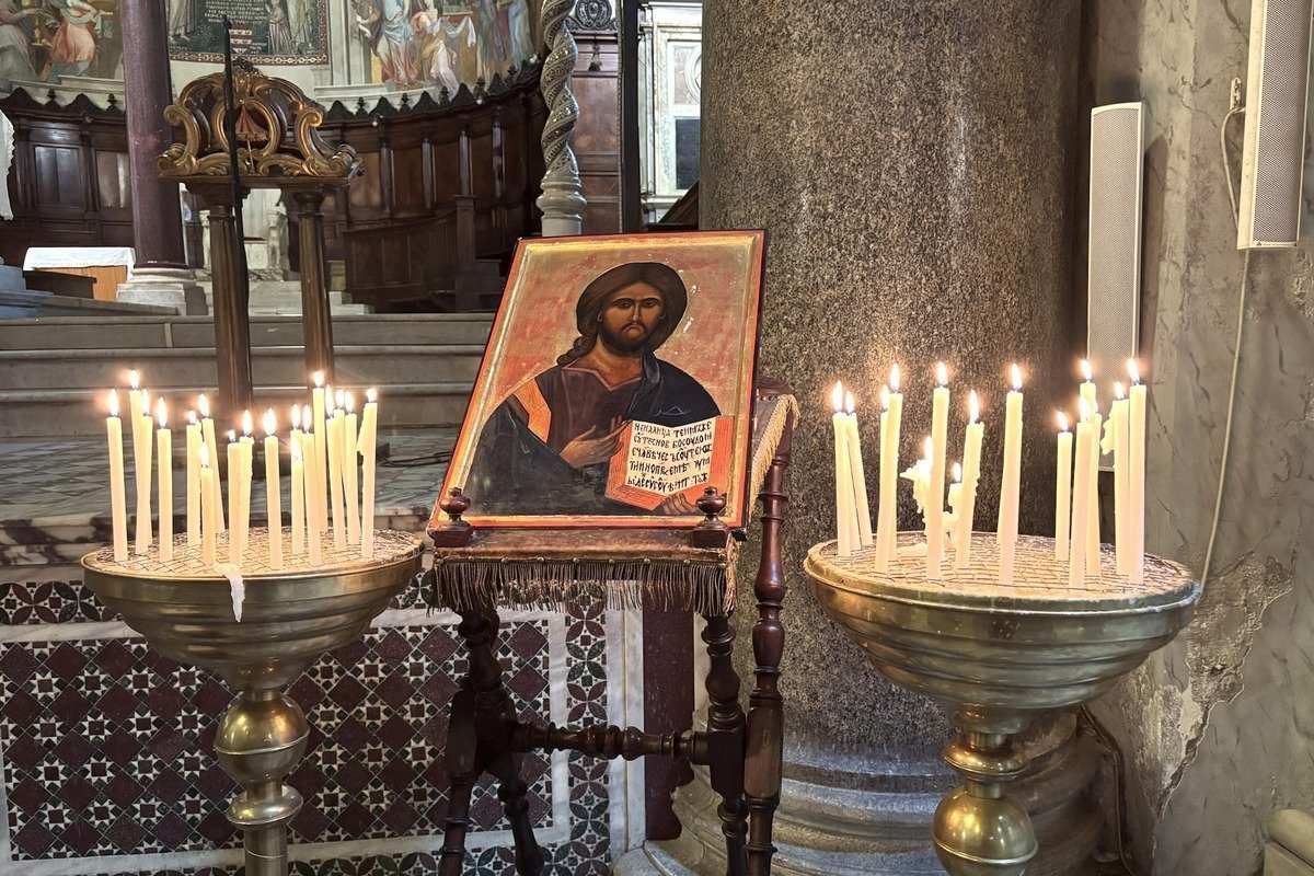 Icône du Christ entourée de deux bougeoirs garnis de cierges allumés