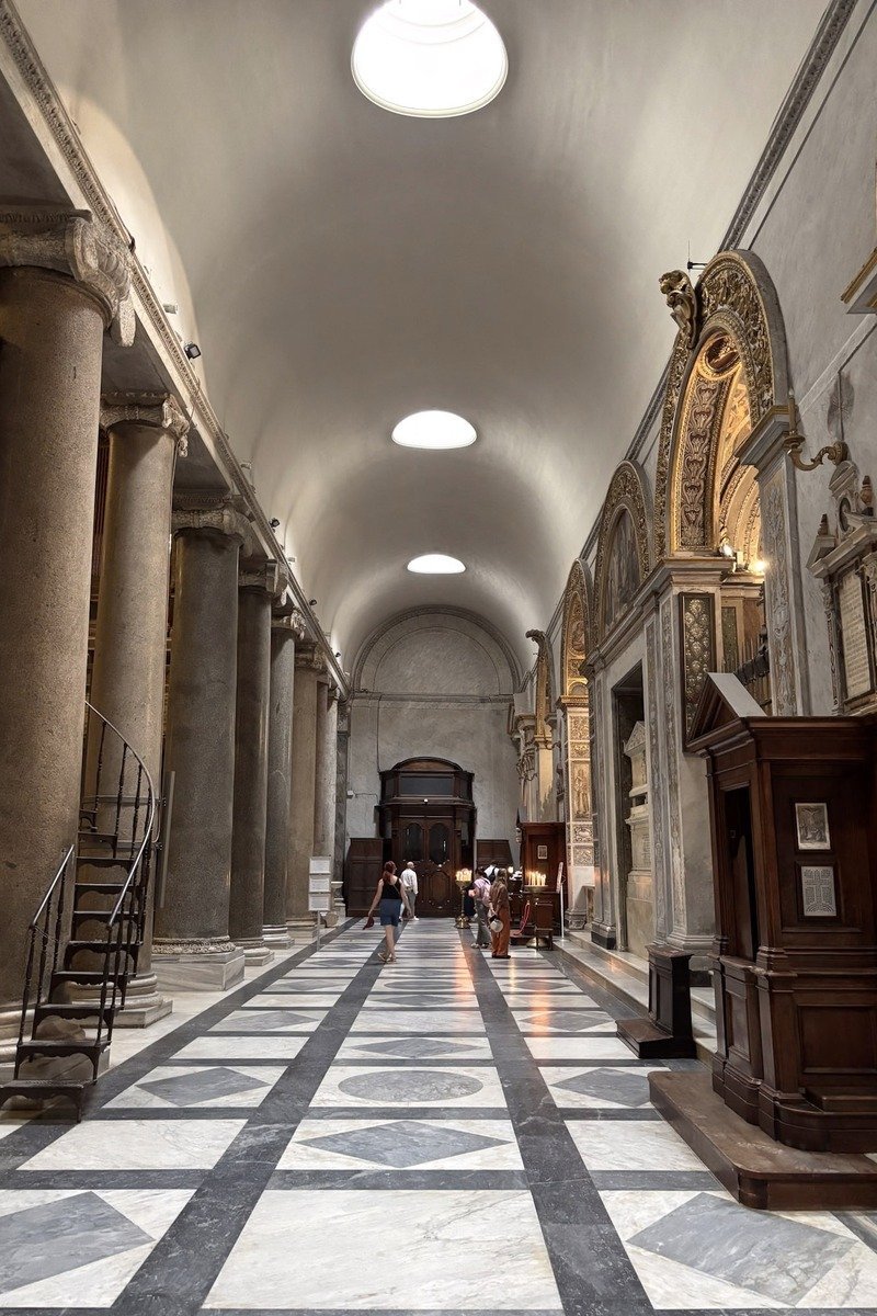 Nef d'une basilique avec colonnes antiques et sol en marbre géométrique