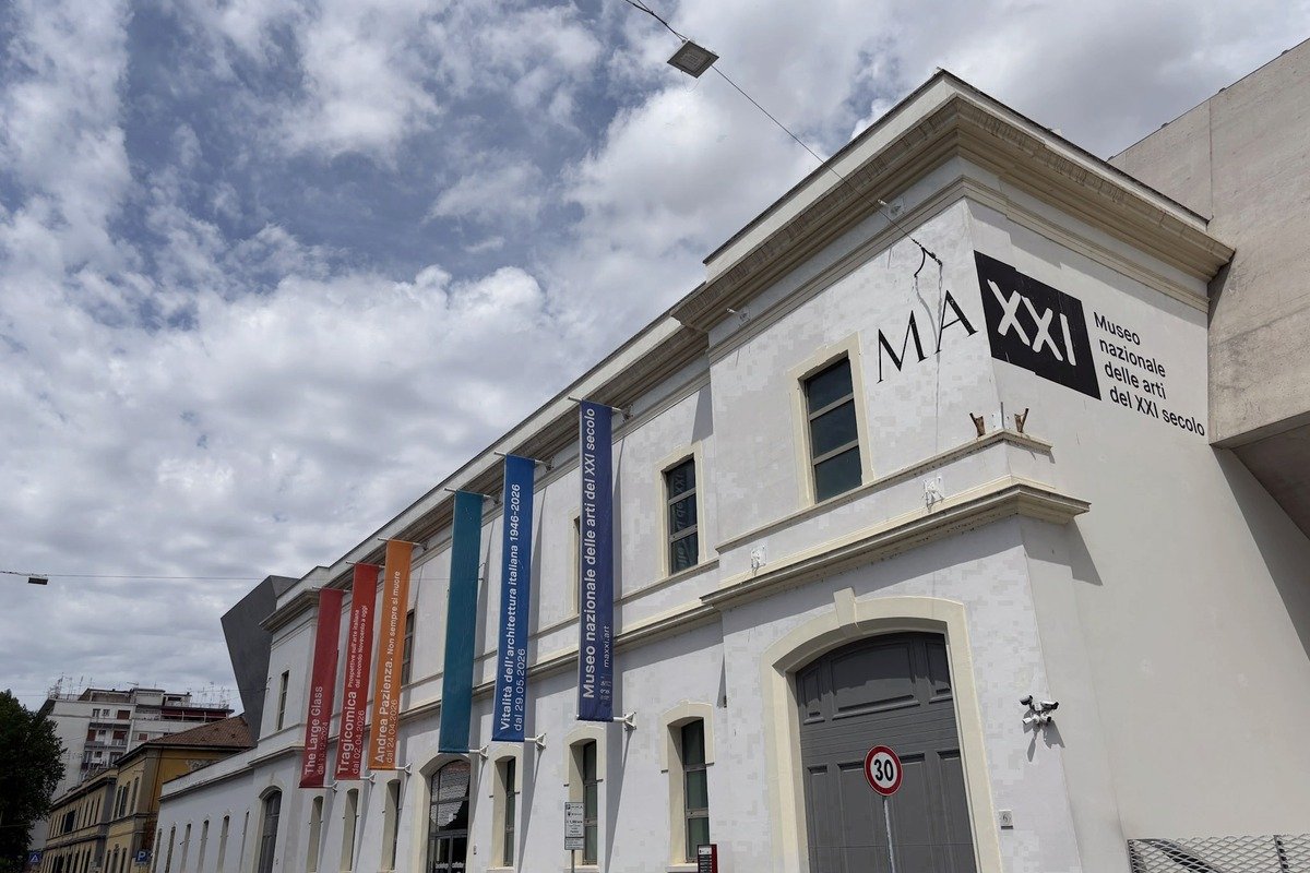 Façade blanche d'un musée d'art avec bannières colorées et logo MAXXI