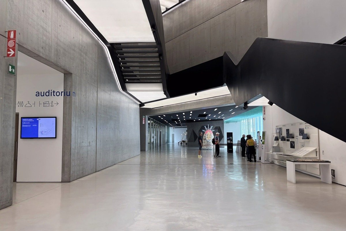 Hall intérieur moderne en béton avec panneau auditorium et visiteurs au fond