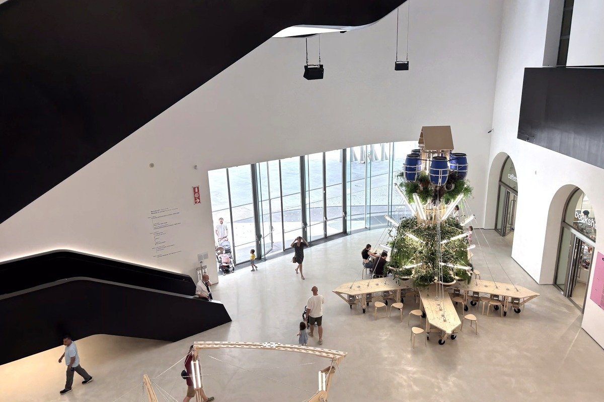 Hall d'un musée contemporain avec installation végétale et visiteurs