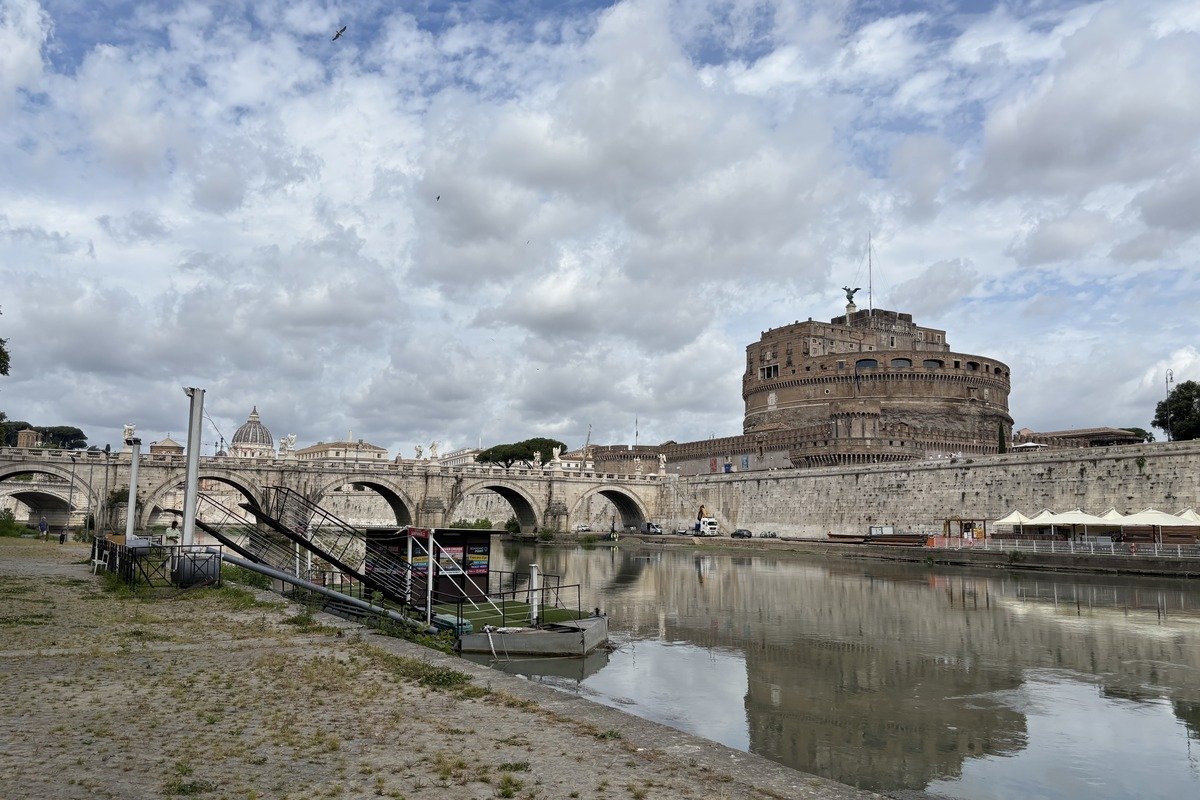 Embarcadère bateau au bord du Tibre avec pont à arches