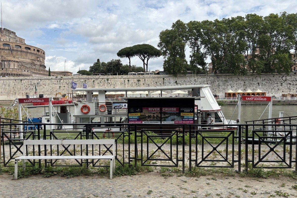 Embarcadère de croisière fluviale devant un château historique et des arbres