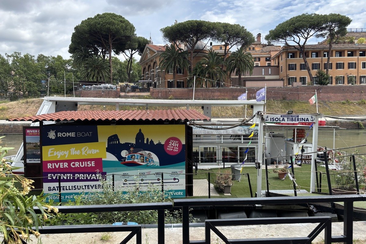Embarcadère de croisière fluviale avec panneau publicitaire coloré et bâtiments ocre