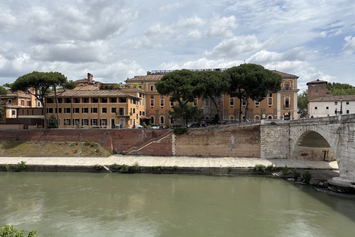 Facades ocre au bord d'un fleuve avec un pont en pierre