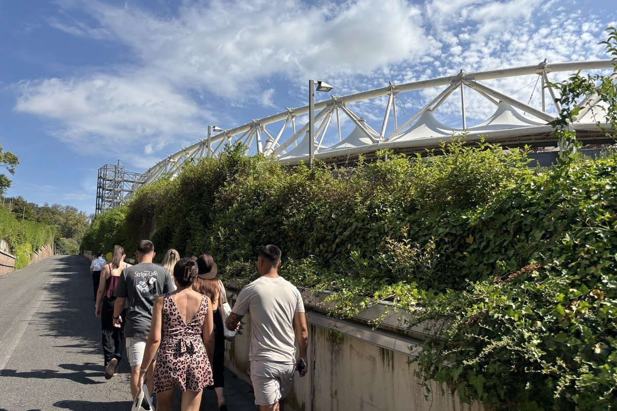 Groupe de personnes marchant sur un chemin longeant le stade olympique