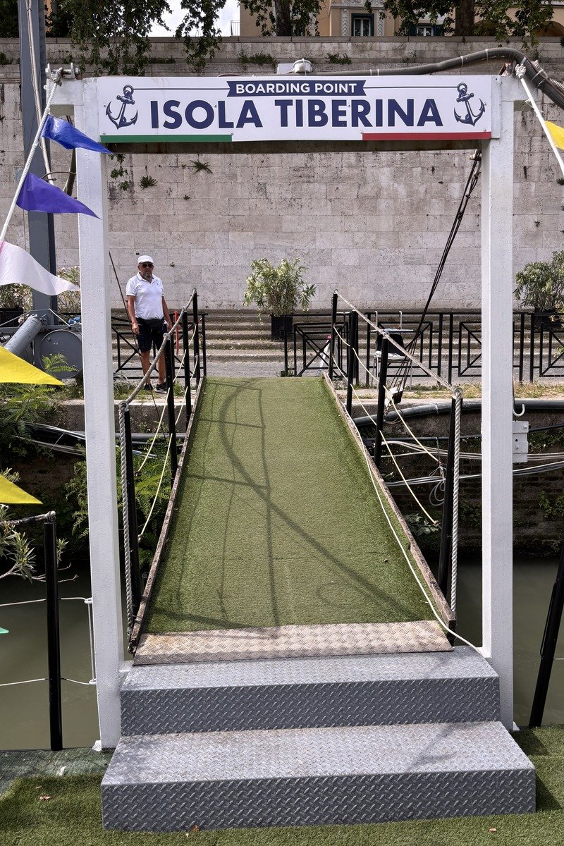 Passerelle d'embarquement avec drapeaux colorés et homme en blanc