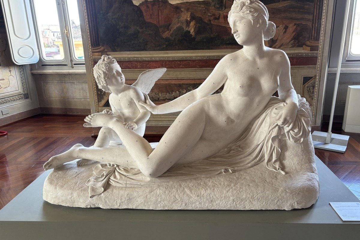 Sculpture en marbre blanc représentant Vénus allongée avec Cupidon ailé