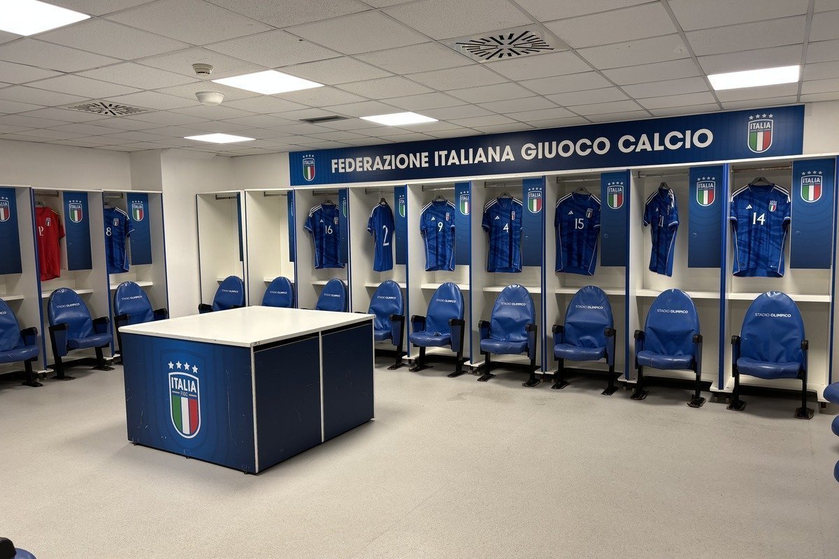 Vestiaire de football avec maillots bleus numérotés alignés sur casiers