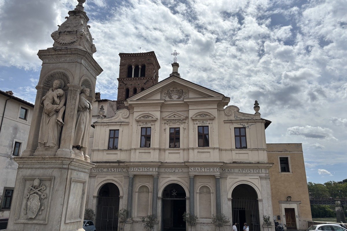Façade baroque d'une basilique avec colonne sculptée au premier plan