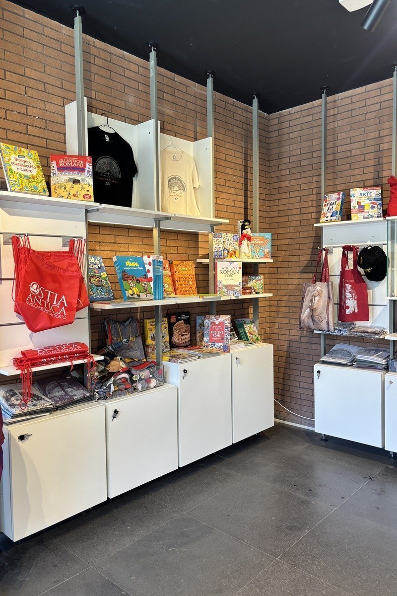 Boutique de souvenirs avec livres colorés, tote bags rouges et t-shirts