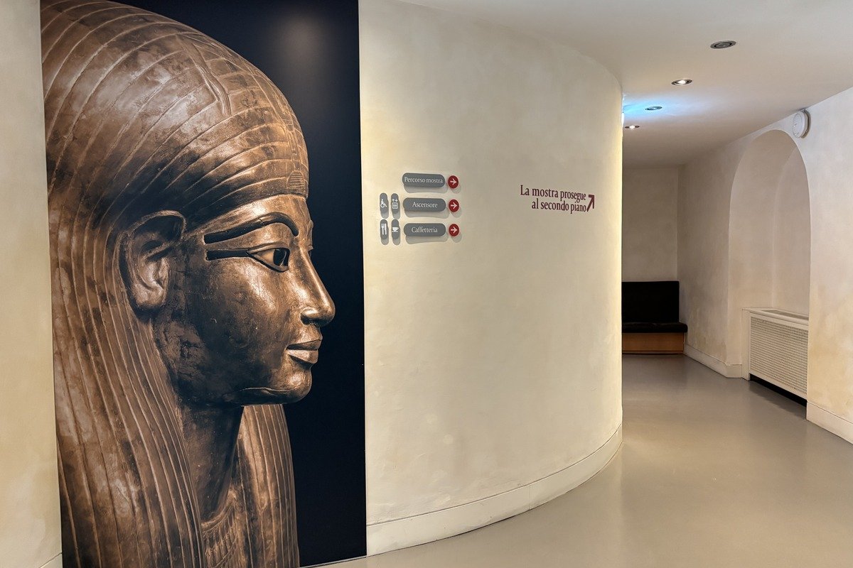 Couloir de musée avec grande affiche d'un masque de sarcophage égyptien