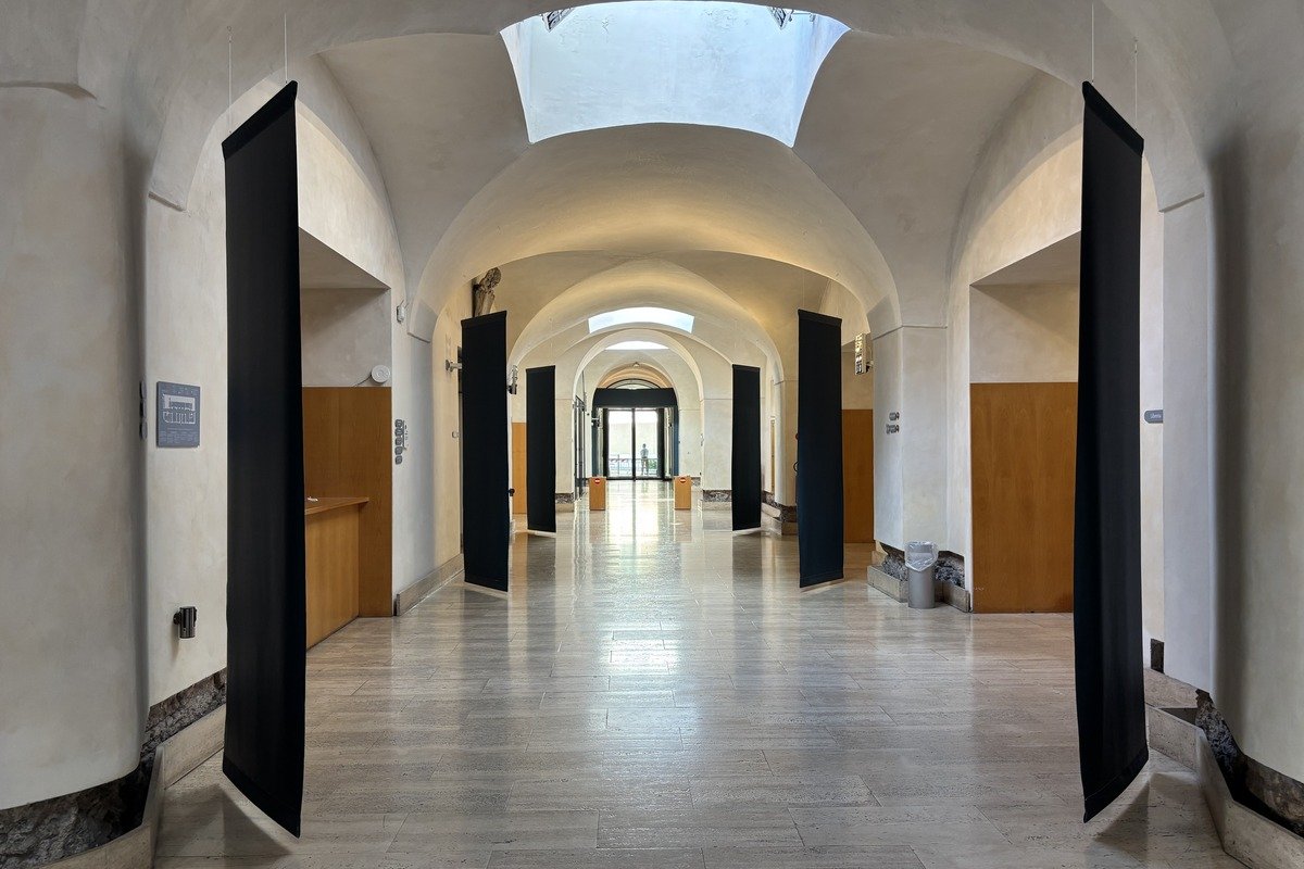 Couloir voûté en pierre avec panneaux noirs et verrière zénithale