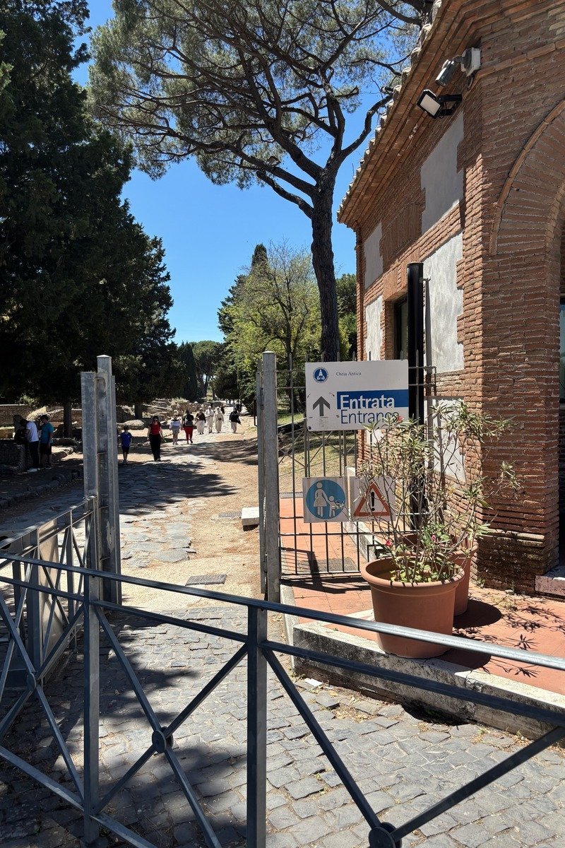 Panneau d'entrée du site archéologique d'Ostia Antica avec allée pavée