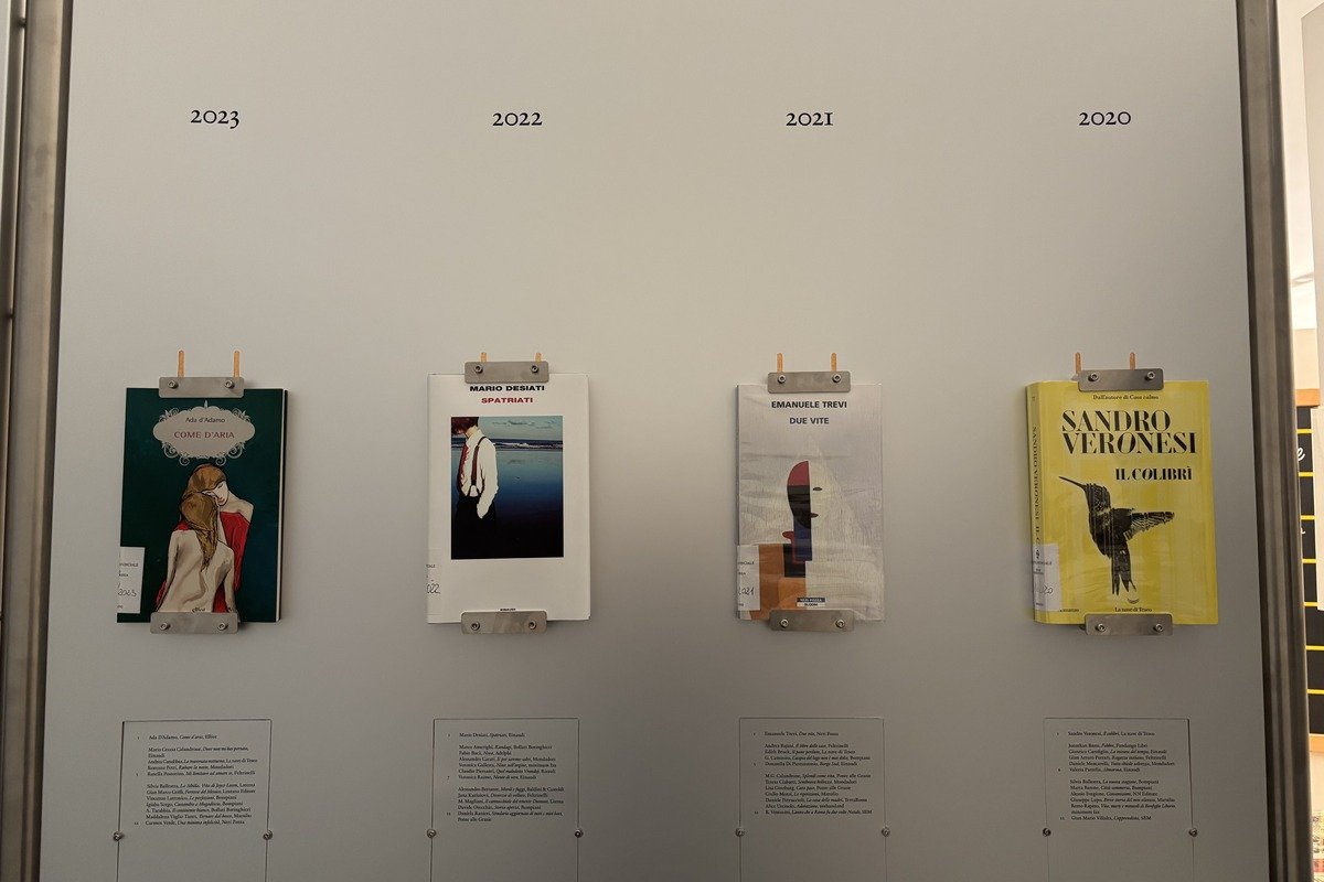 Quatre couvertures de livres primés accrochées sur un panneau gris par années