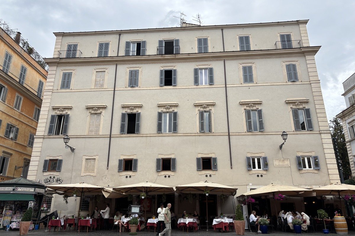 Façade d'immeuble ancien avec terrasse de restaurant animée au rez-de-chaussée