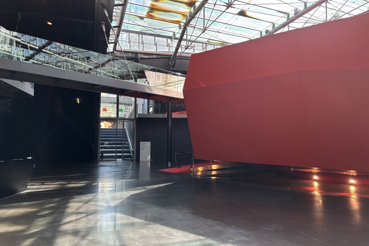 Hall intérieur avec grande cloison rouge et verrière zénithale lumineuse