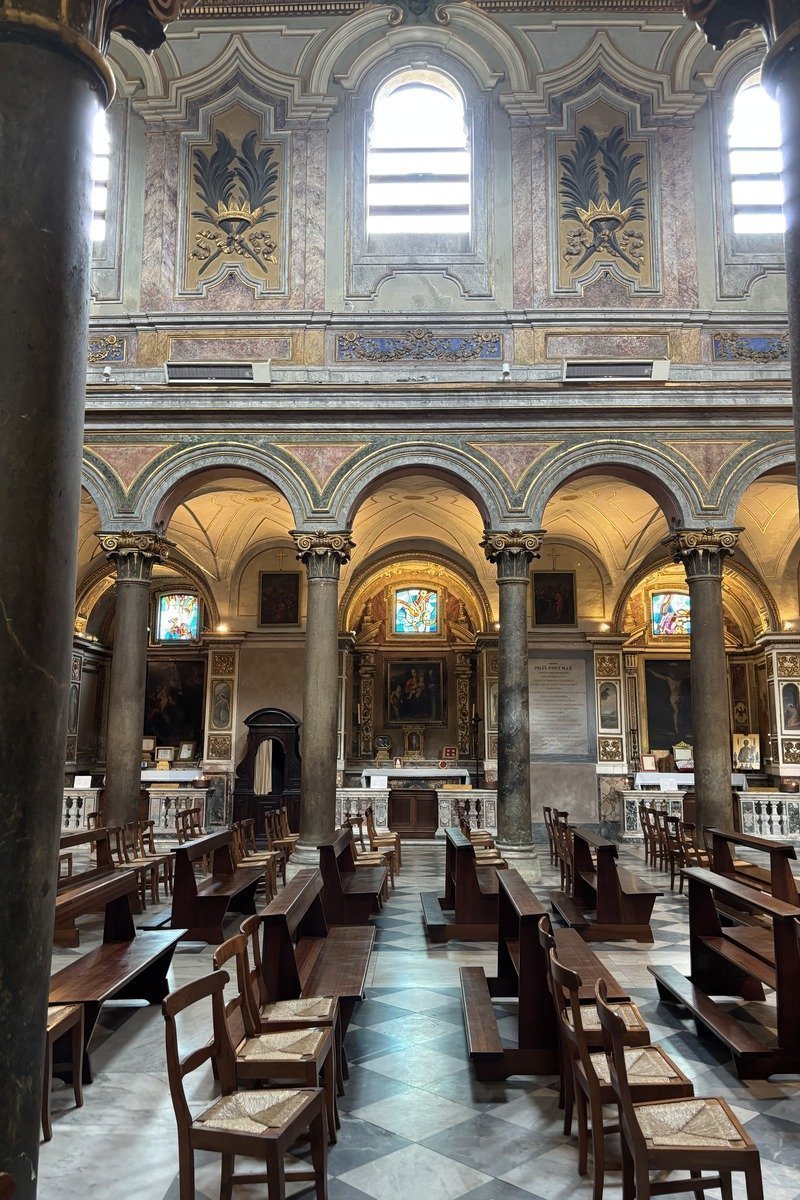 Nef d'une église avec rangées de bancs en bois et colonnes