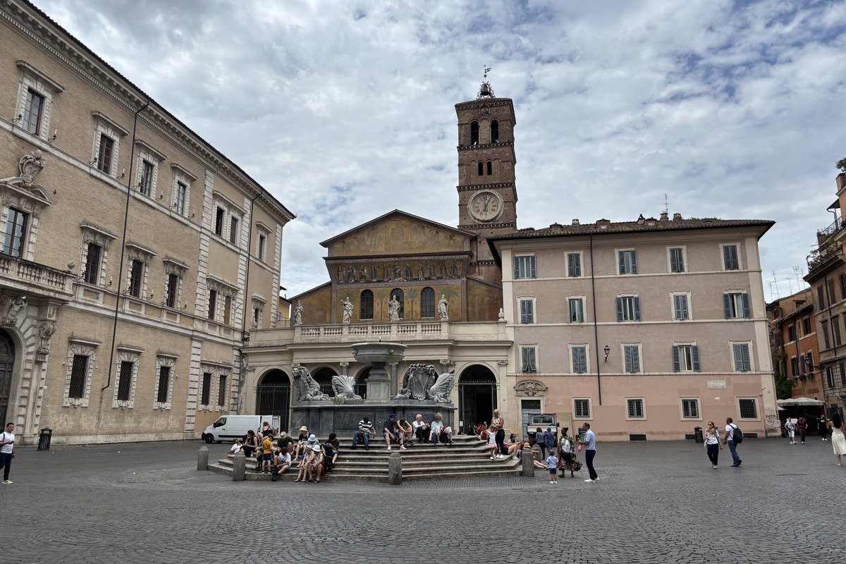 Place pavée animée avec fontaine baroque et église à clocher