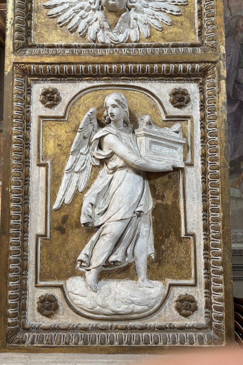 Bas-relief sculpté d'un ange portant un coffret sur fond doré