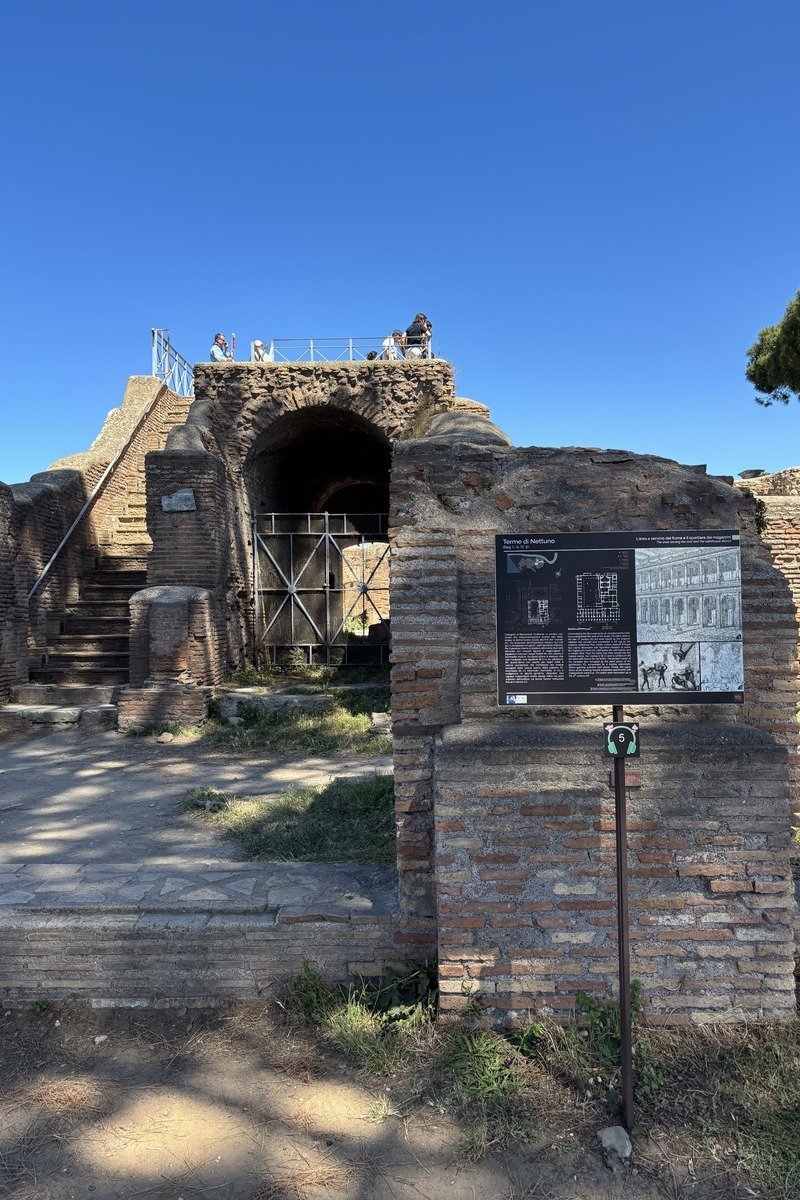 Ruines de briques antiques avec panneau explicatif des Thermes de Neptune