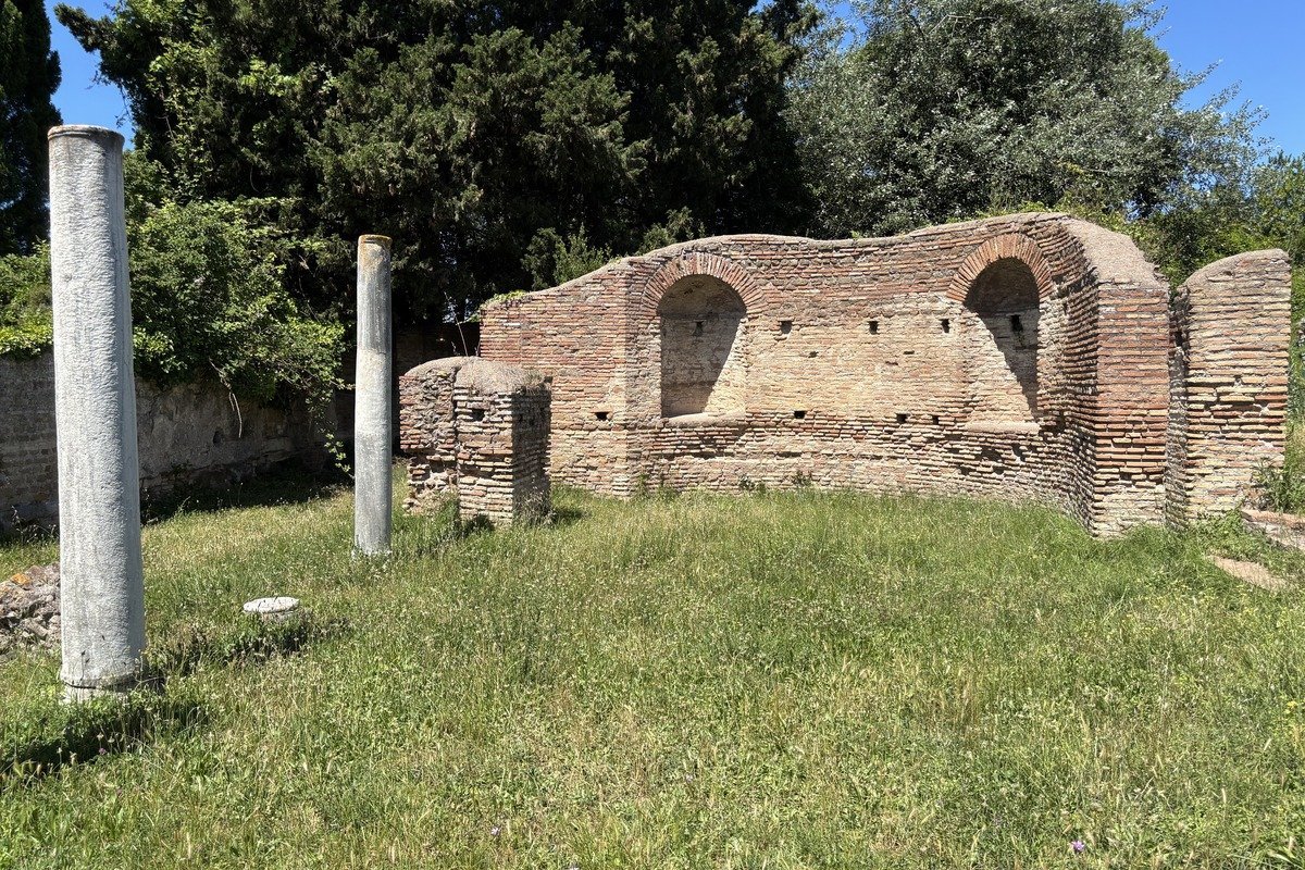 Ruines de briques anciennes avec arches et colonnes de marbre dans un pré