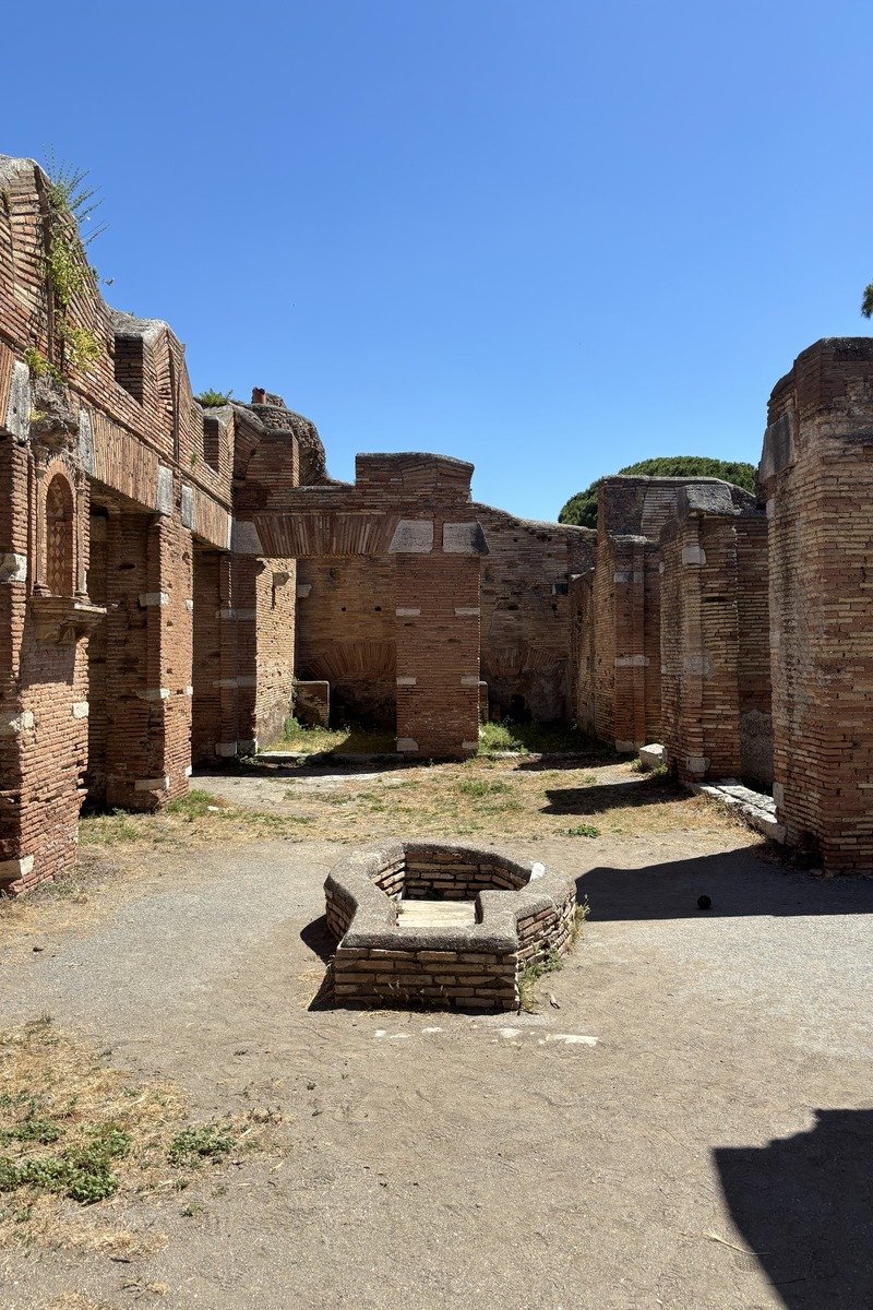 Cour de ruines antiques en briques avec un puits central
