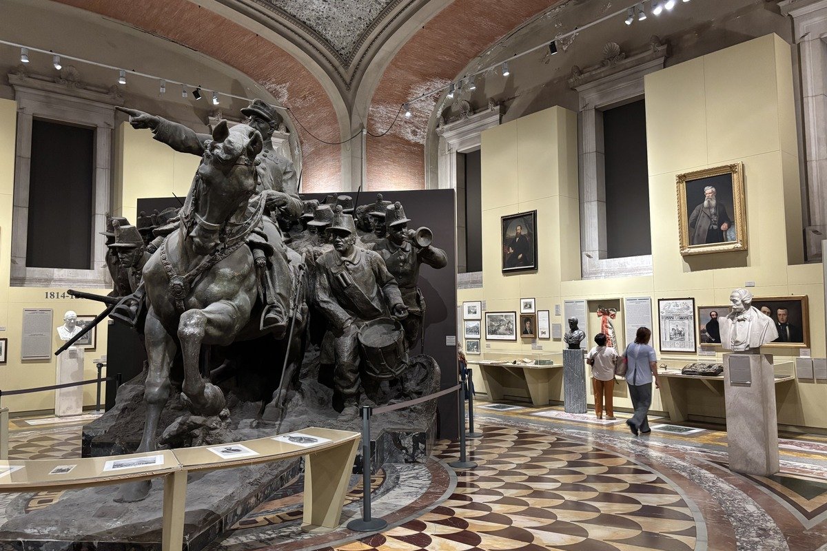 Grande sculpture en bronze de soldats à cheval dans une salle de musée voûtée