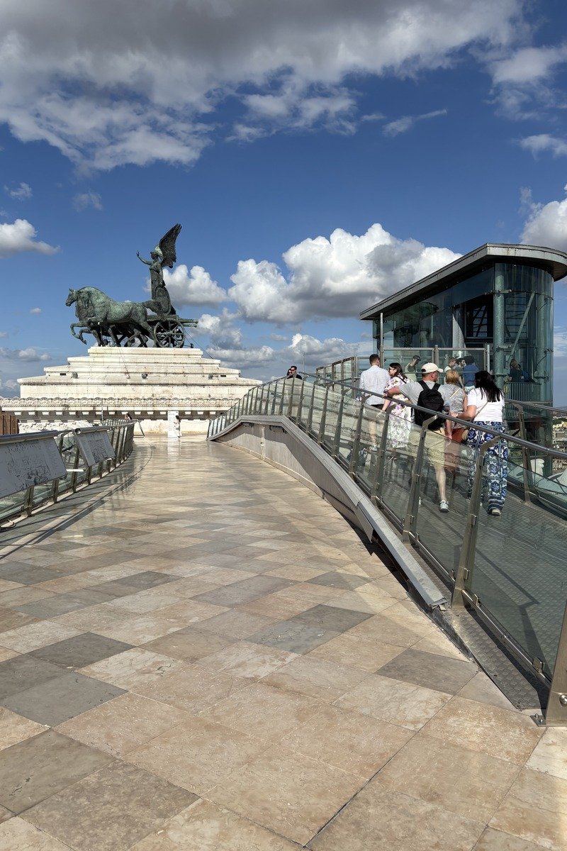 Terrasse panoramique avec quadrige en bronze et visiteurs sous ciel nuageux