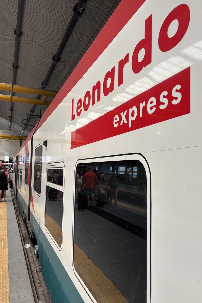 Flanc blanc et rouge du train Leonardo Express à quai avec voyageurs