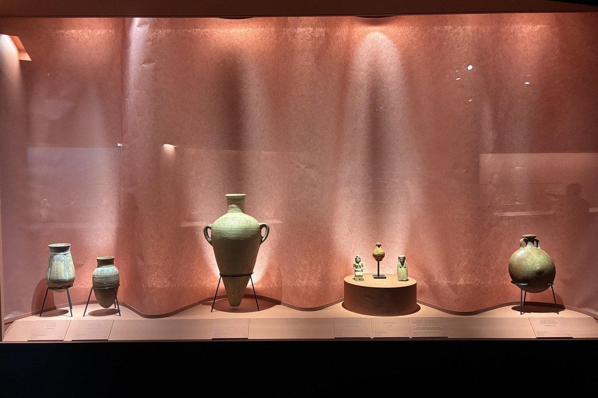 Vitrine de musée présentant des vases et statuettes antiques en faïence