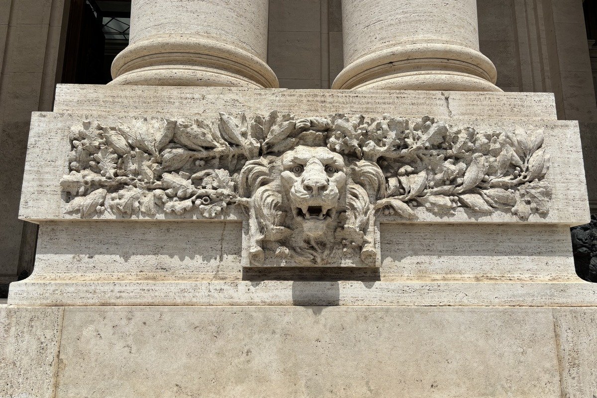 Bas-relief sculpté en pierre représentant une tête de lion entourée de feuillages