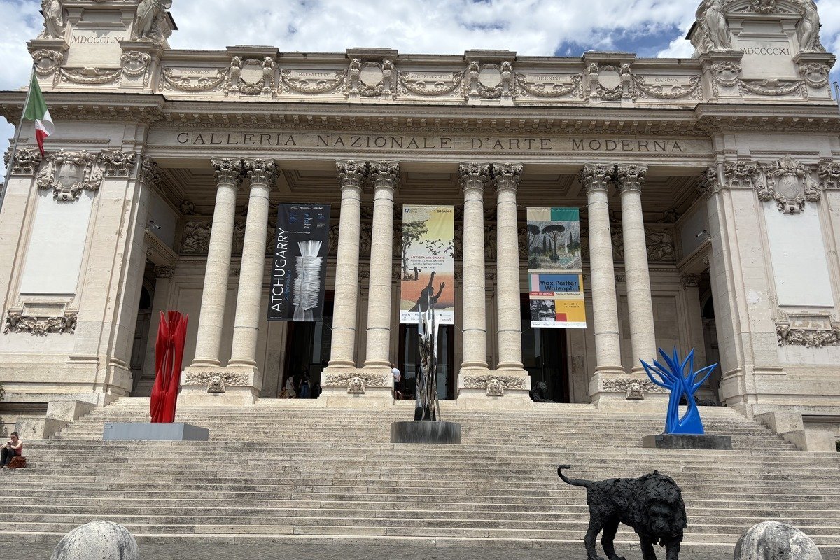 Façade néoclassique d'un musée avec sculptures contemporaines sur les marches
