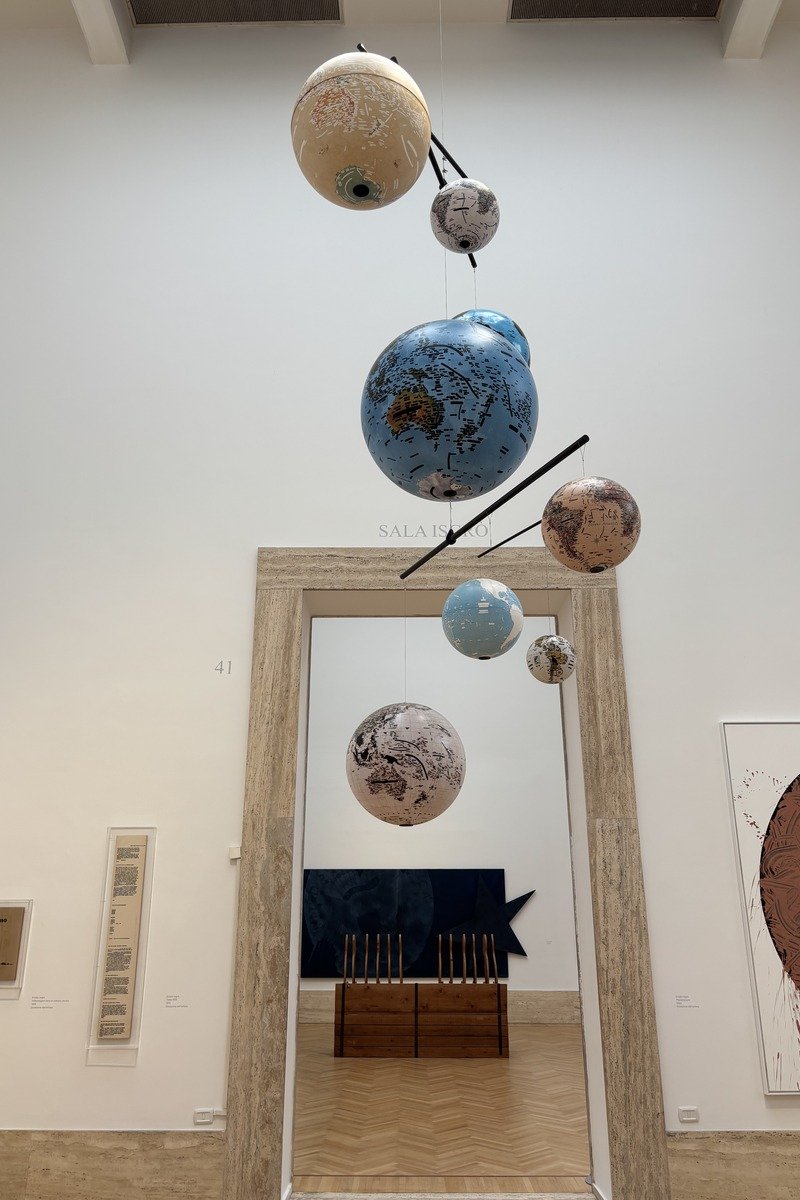 Installation de globes terrestres suspendus dans une salle d'exposition lumineuse