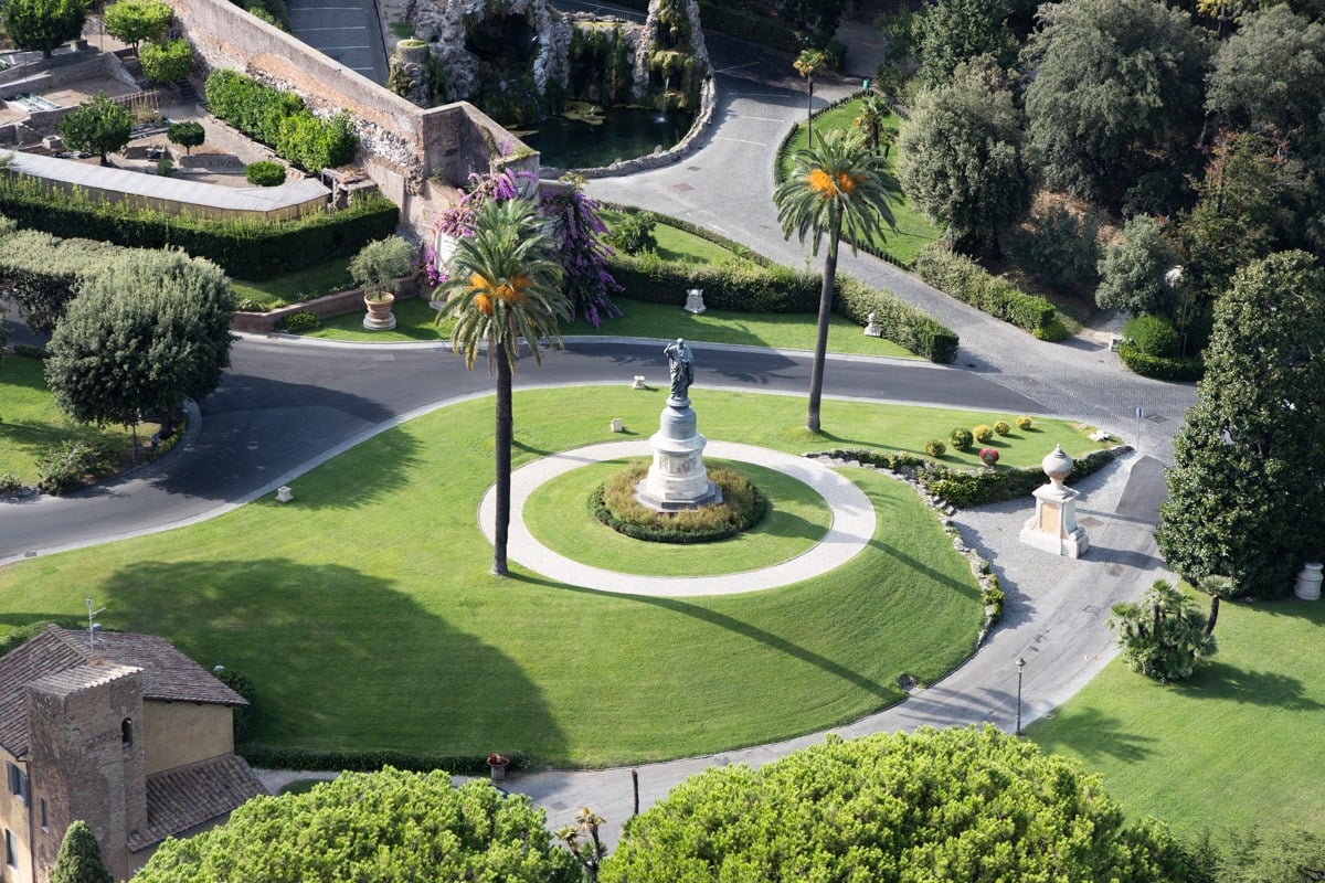 Vue aérienne de jardins verdoyants avec statue centrale et palmiers
