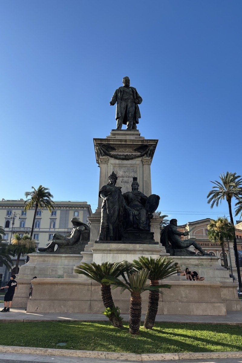 Monument en bronze de Camilia Benso sur piédestal de marbre entouré de palmiers