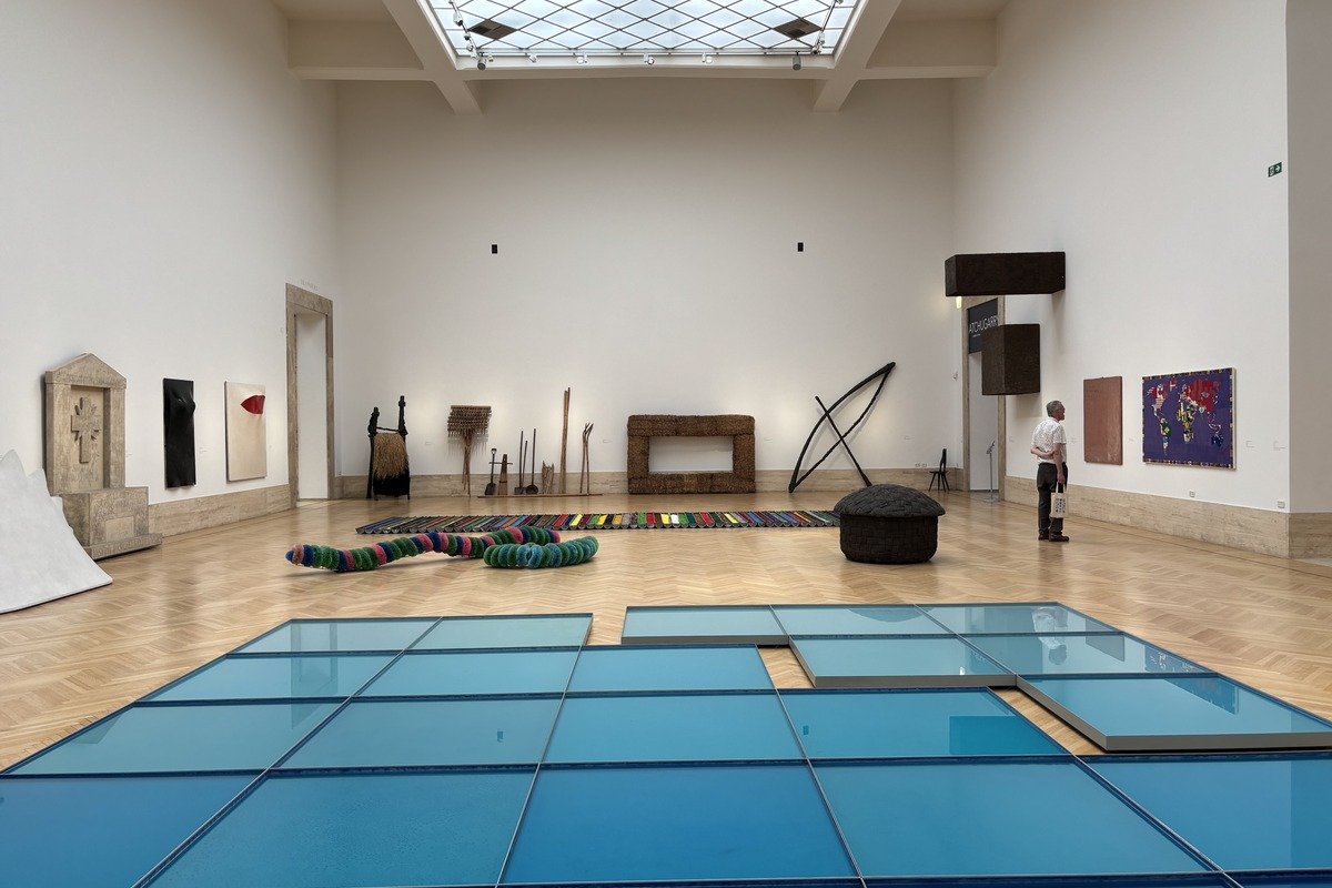 Salle de musée avec sculptures contemporaines et installation de panneaux bleus au sol
