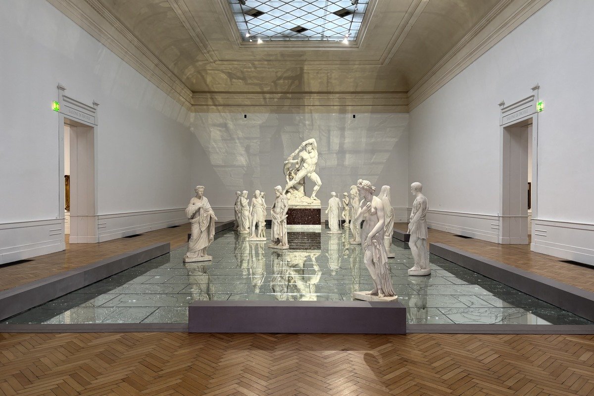 Salle de musée avec groupe de sculptures en marbre blanc sur socle