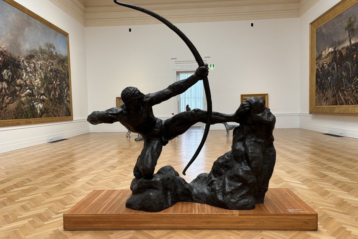 Sculpture en bronze d'un archer bandant son arc dans une salle de musée