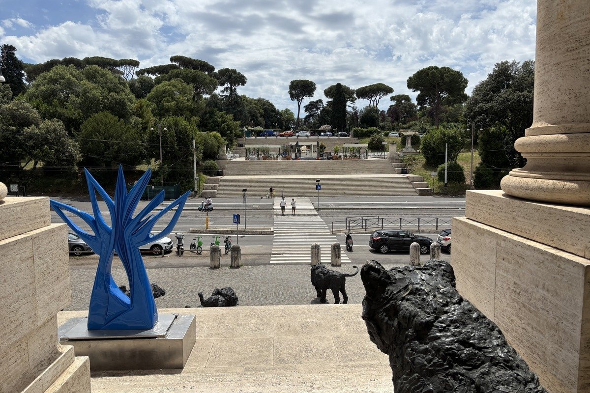 Sculpture bleue abstraite et statue de lion en bronze sur un parvis monumental