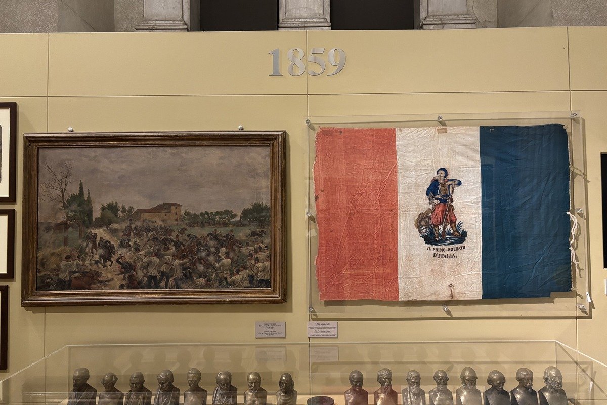Salle de musée avec tableau de bataille, drapeau tricolore et bustes en bronze